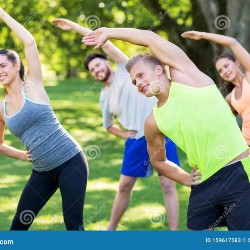 A group of people doing basic standing quad stretch for physical fitness